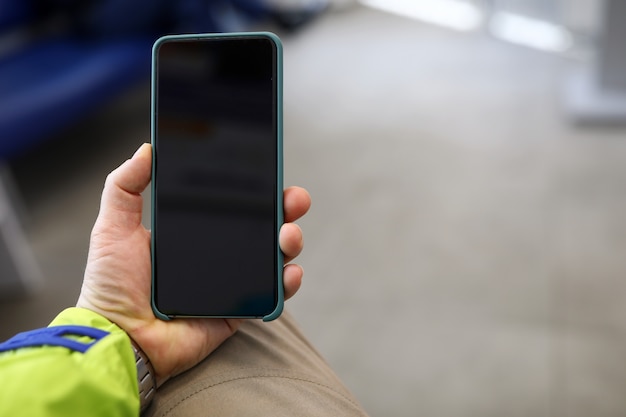 Guy in a jacket holds an electronic device