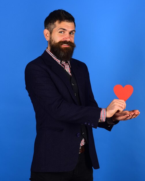 Guy in love holds heart on blue background