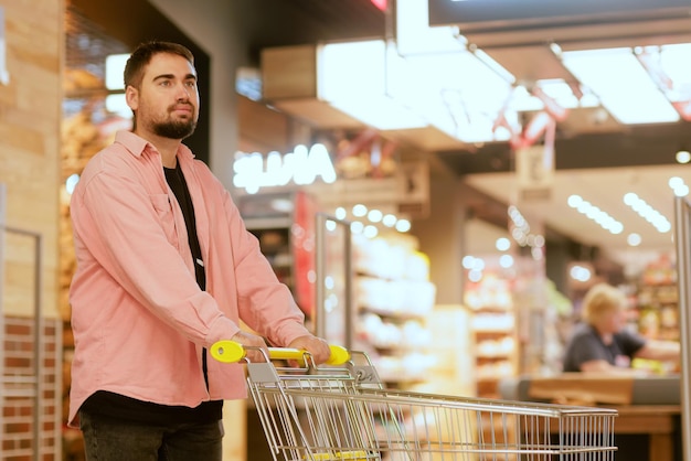 The guy makes purchases in the supermarket the concept of shopping