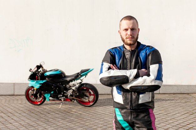 Guy motorcyclist in professional protective equipment stands near sports motorcycle