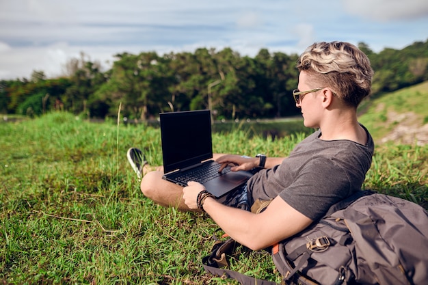 Photo guy in nature with a laptop works