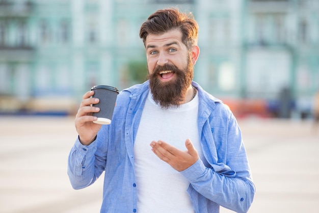 Guy offering coffee outside presenting guy offering coffee in the street