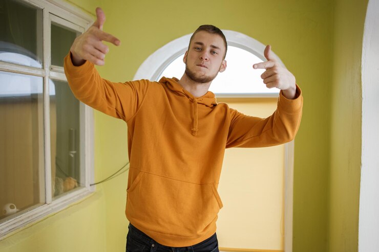 Guy in orange clothes dancing waving his arms