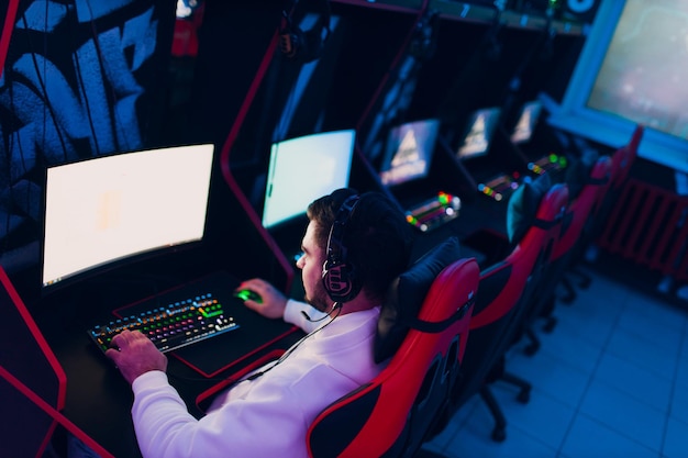 Guy playing gaming game on computer at game club