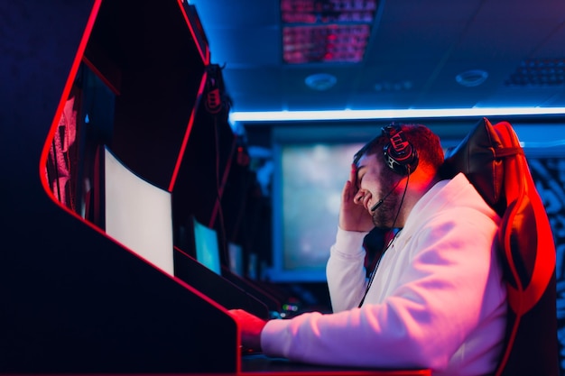 Guy playing gaming game on computer at game club