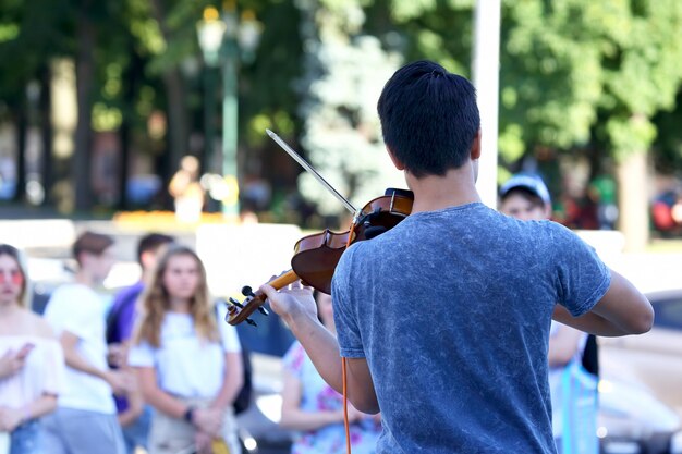 Guy suona il violino per la gente di strada