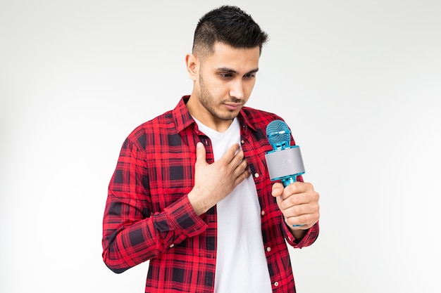 Guy preparing a speech holding a microphone in his hand on a white isolated background with copy space.