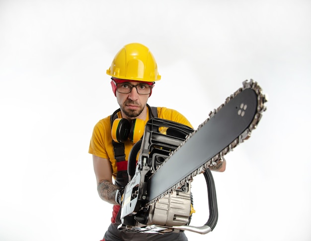 The guy in protective coveralls with a chainsaw on a white background