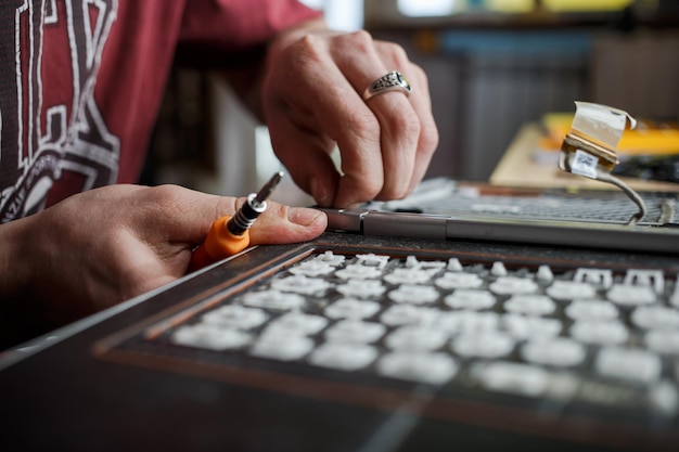 Guy repairs laptop at home