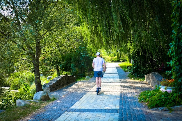 男は公園で電動スクーターに乗る。