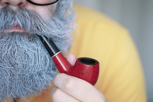 Guy rookt tabakspijp Hipster met grijze baard en snor Slechte gewoontes conce