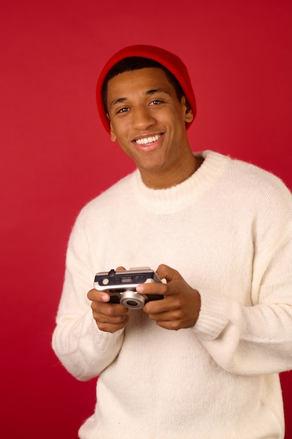 A guy in santa hat making with a camera in hands