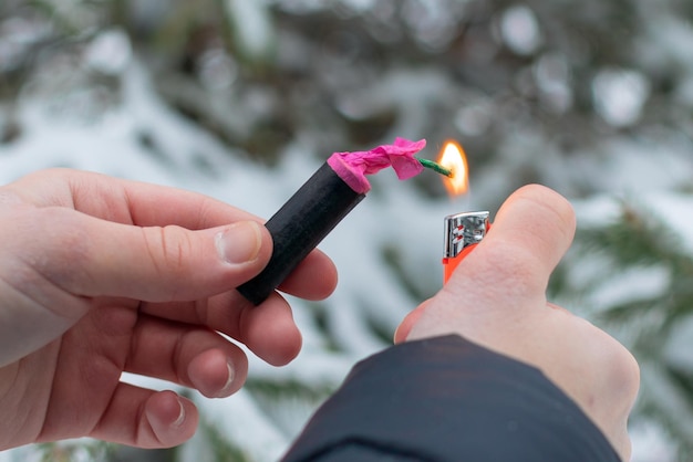 Guy sets fire to the flash noise firecracker outdoors