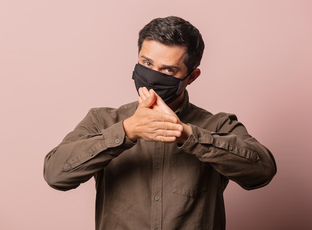 Guy in shirt and face mask on pink