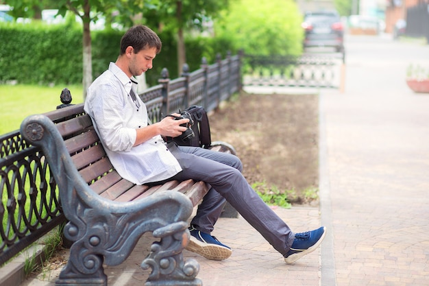 Guy sits on bench and looks the camera