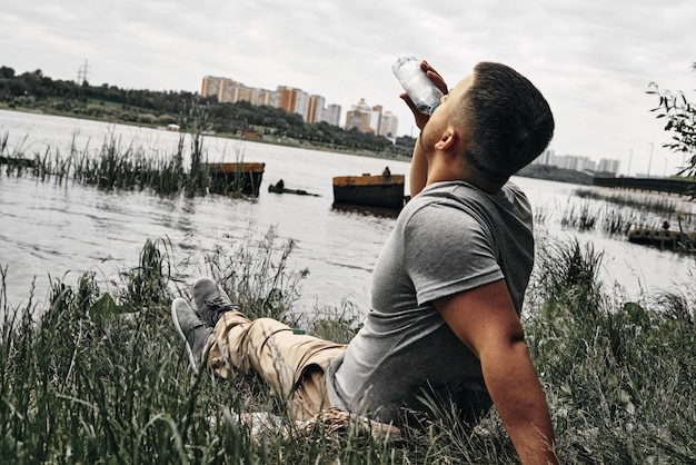 Guy sits in a city park and enjoys nature