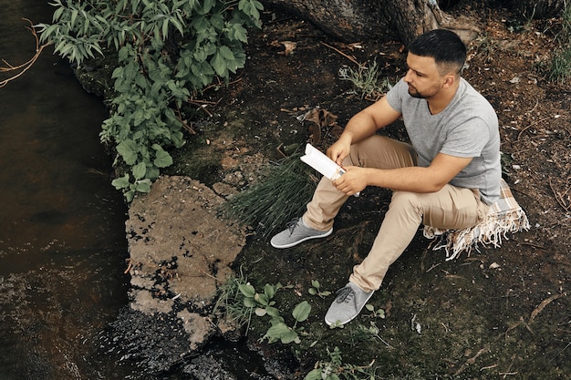 Guy sits in a city park and enjoys nature