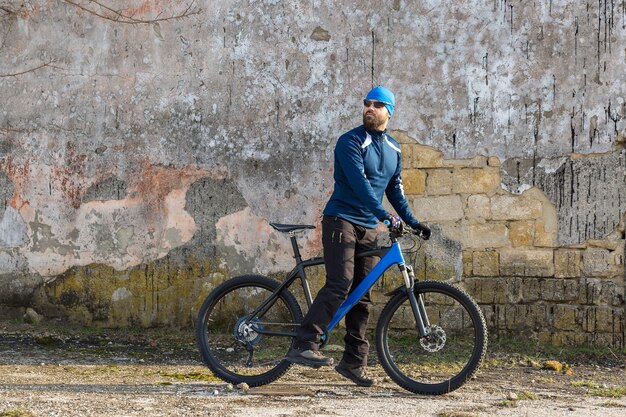에어 서스펜션 포크가 달린 현대적인 산악 탄소 자전거를 타고 운동복을 입은 남자