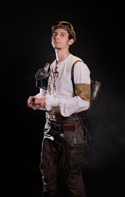 A guy in a steampunk image a pilot or a mechanic retro style fantastic image portrait on black