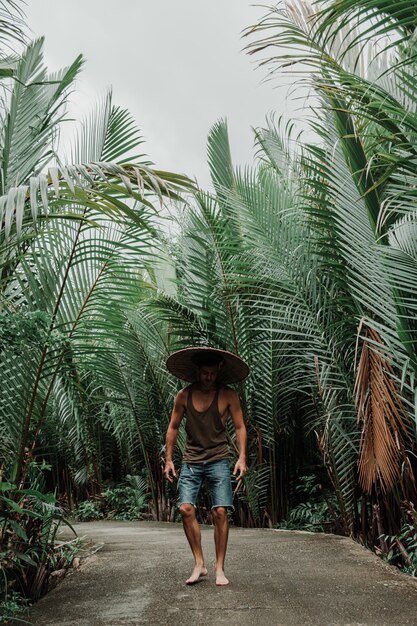 guy in a straw hat in tropical environment