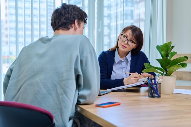 guy student at therapy meeting with psychologist mentor in college office