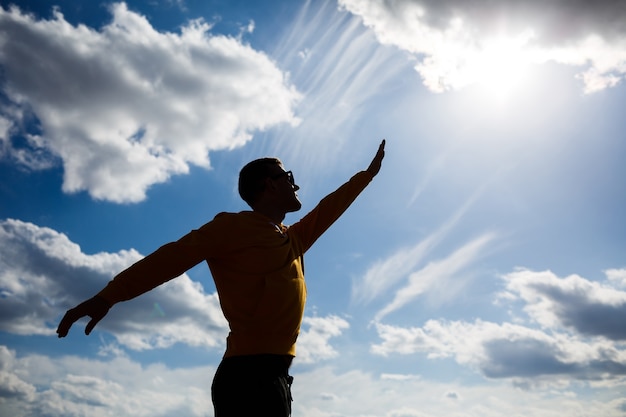 Guy toeristische freelancer op een achtergrond van blauwe lucht met witte wolken, zonnige dag, natuur en menselijke vrijheid