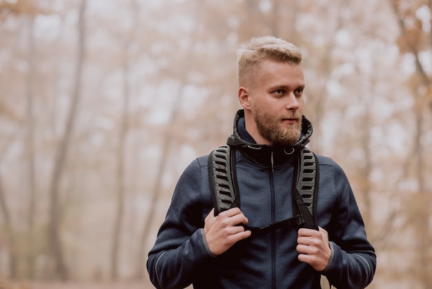 Guy tourist walks in a foggy autumn forest