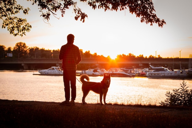 The guy walking his dog at sunset