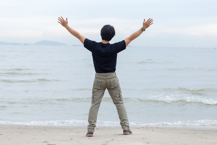 Photo 카고 바지를 입고 해변에 서있는 남자