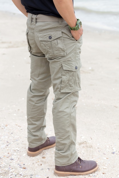 Foto ragazzo che indossa pantaloni cargo e in piedi sulla spiaggia