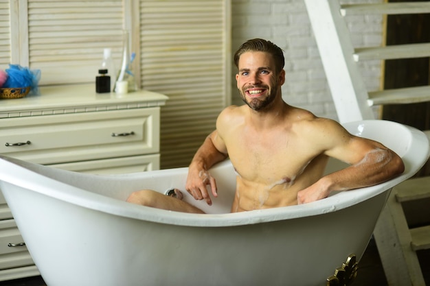 Guy in white bathroom with stairs on background