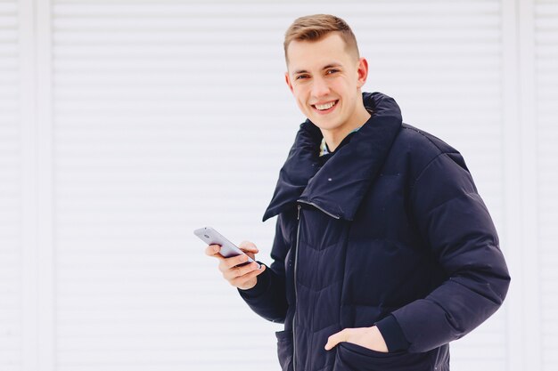 Guy in winter jacket writes sms