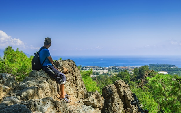 Olympos 산 꼭대기에 배낭을 가진 사람은 터키의 Kemer시를 봅니다.