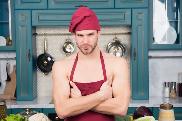 Guy with beard on serious face, blond hair in blue shirt hold hands in kitchen. Cook food concept