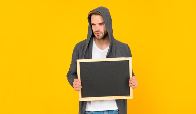 Guy with bristle holding chalkboard with copy space on yellow background here