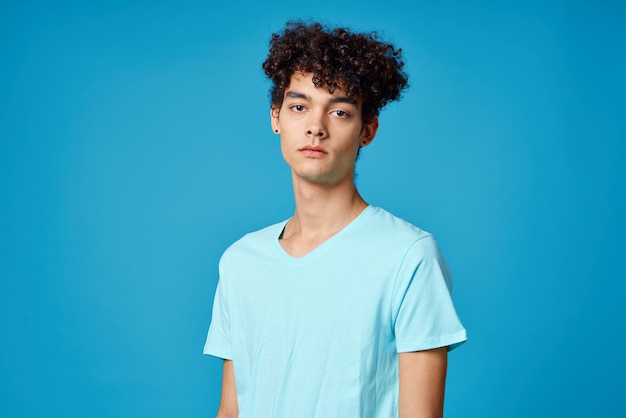 Guy with curly hair in blue tshirt cropped view studio