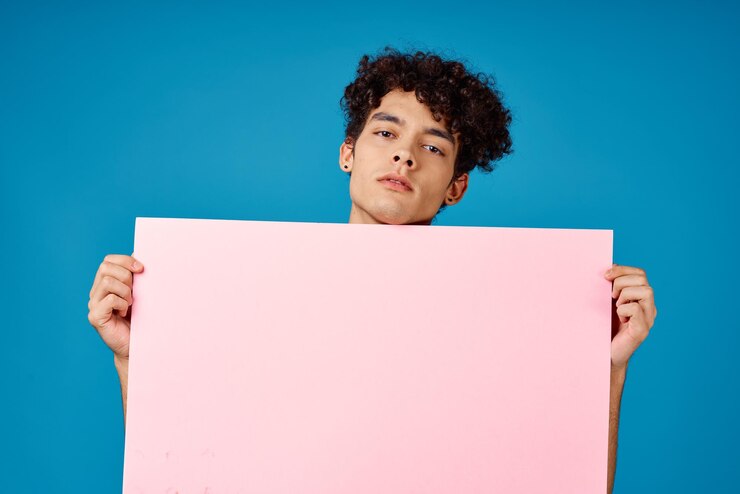 Photo guy with curly hair holding pink poster mockup high quality photo