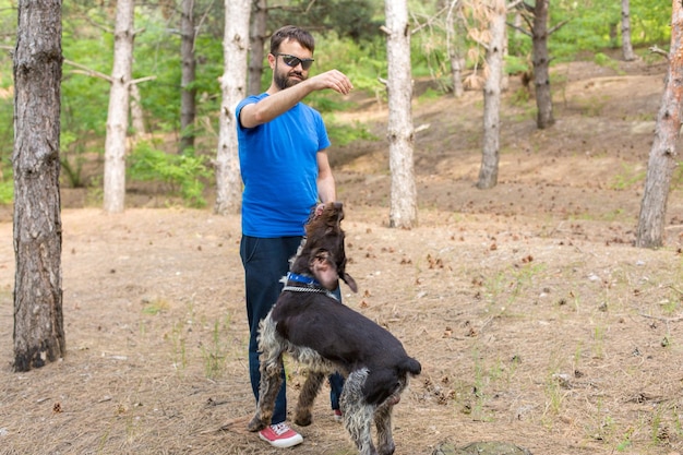 公園で犬と一緒の男ジャーマンハンティングウォッチドッグdrahthaar