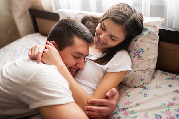 A guy with a girl, cuddling in bed