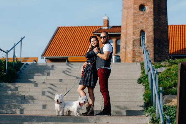 Guy with a girl walking around the city together with two dogs