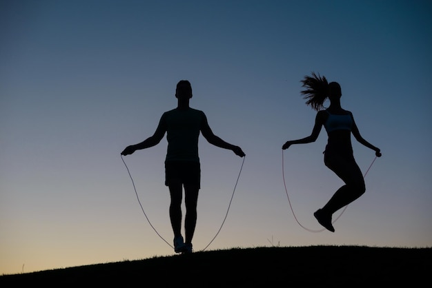 Photo guy with girl warming up on a skipping rope.