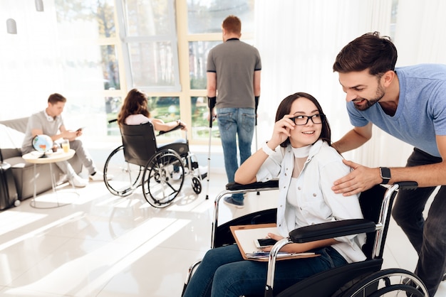 A guy with a girl in a wheelchair is traveling.