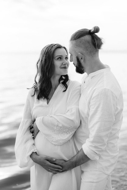 A guy with a girl in white clothes on the seashore