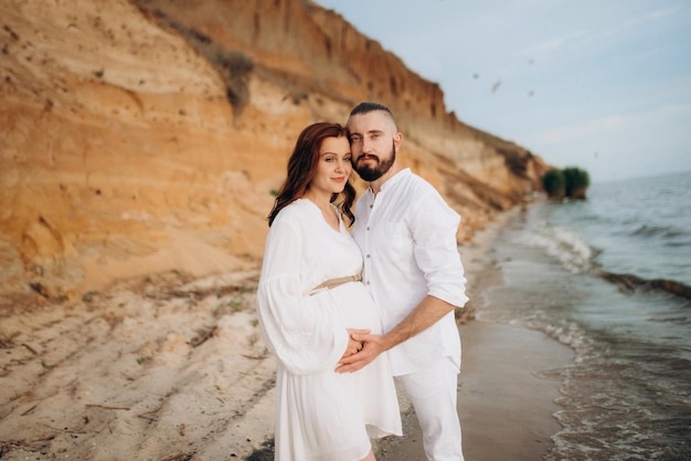 A guy with a girl in white clothes on the seashore