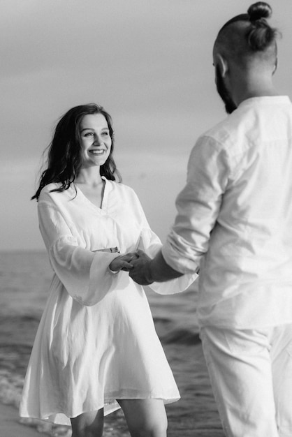 A guy with a girl in white clothes on the seashore