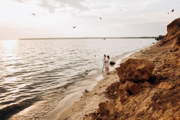 A guy with a girl in white clothes on the seashore