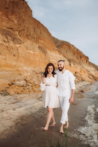 A guy with a girl in white clothes on the seashore