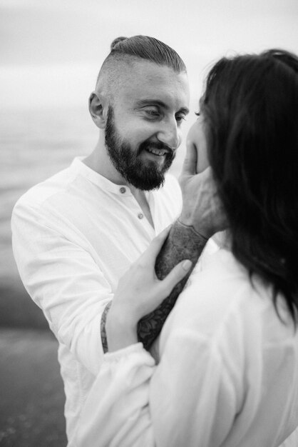 A guy with a girl in white clothes on the seashore