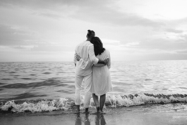 A guy with a girl in white clothes on the seashore