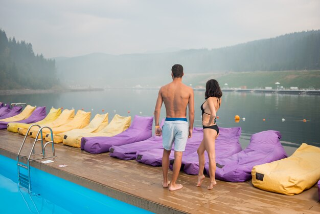 Ragazzo con la ragazza vicino alla piscina del resort di lusso